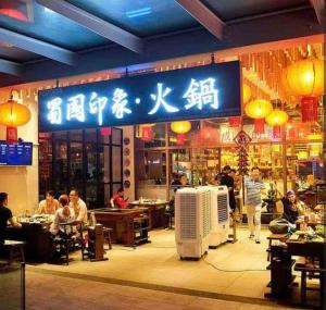a restaurant with people sitting at tables in front of it at Sunway Nexis SoHo #Golf course view in Petaling Jaya