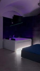 a room with a white table with purple lighting at HomeSuite45 in Catania