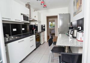 a kitchen with white appliances and black and white cabinets at Charmant appartement avec terrasse dans villa in Strasbourg