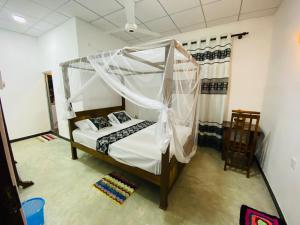a bedroom with a bed with a canopy at Sparrow Villa in Talpe