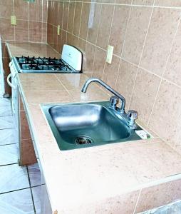a kitchen counter with a sink and a stove at Departamento Renata Huatulco in Santa Cruz Huatulco