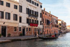 a gondola on a canal in front of buildings at Ca' Bonfadini Historic Experience in Venice