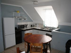 a kitchen with a table and a sink and a refrigerator at Crow's Nest Self-Catering Accommodation in Saldanha +13 photos