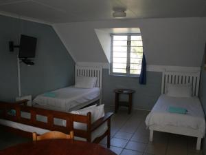 a small room with two beds and a window at Crow's Nest Self-Catering Accommodation in Saldanha