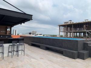 a rooftop bar with chairs and a pool on a building at Equipetrol Edificio Tuareg 110 in Santa Cruz de la Sierra