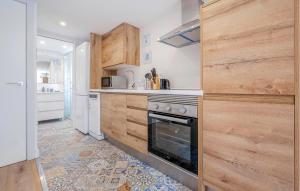 cocina con armarios de madera y fogones en Amazing Apartment In Sant Pere De Ribes, en Sant Pere de Ribes