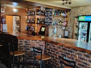 a brick bar with stools in a restaurant at Crow's Nest Self-Catering Accommodation in Saldanha