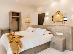 a bedroom with a large bed with white sheets at Jodev Farmstay in Krugersdorp