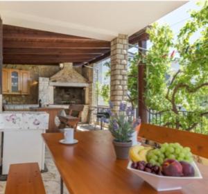 Una mesa de madera con un bol de fruta encima. en Regina 2, en Banjole