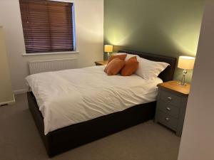a bed with two pillows on it in a bedroom at Superb Central Flat, 3 mins to Station and Parking in Staines upon Thames