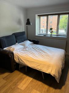 a bedroom with a bed and a window at Superb Central Flat, 3 mins to Station and Parking in Staines upon Thames