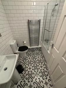 a white bathroom with a toilet and a sink at Superb Central Flat, 3 mins to Station and Parking in Staines upon Thames