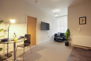 ein Wohnzimmer mit einem Tisch und einem Stuhl in der Unterkunft Vibrant 1 Bed Apartment, FREE Parking, North Church St, Sheffield City Centre - Hosted by Stay Host Save in Midland