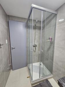 a shower with a glass door in a bathroom at Atardecer Sur Belgrano in Ushuaia +2 photos