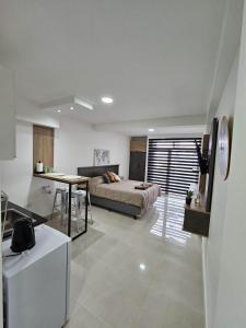 a bedroom with a bed and a table and a kitchen at Atardecer Sur Belgrano in Ushuaia