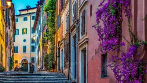 an alley with stairs in an old town with purple flowers at The Inn at the Roman Forum Autograph Collection - The Inn At The Roman Forum Holidays in Rome