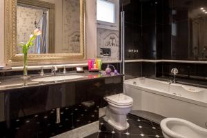 a bathroom with a sink and a toilet and a bath tub at The Inn at the Roman Forum Autograph Collection - The Inn At The Roman Forum Holidays in Rome