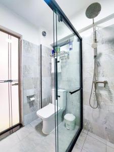 a bathroom with a toilet and a glass shower at Carolina Homes - Kilimani in Nairobi