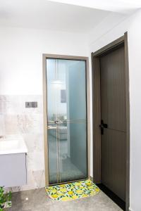 a glass shower door in a bathroom next to a sink at Carolina Homes - Kilimani in Nairobi +9 photos