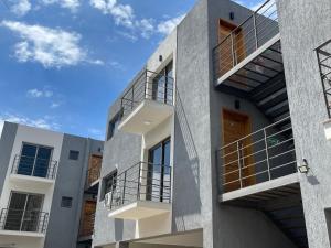 an apartment building with balconies and a blue sky at Elite Mendoza Park in La Cieneguita