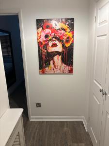 a painting of a woman with flowers on a wall at Superb Central Flat, 3 mins to Station and Parking in Staines upon Thames