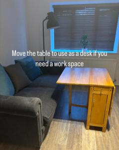 a living room with a couch and a wooden table at Superb Central Flat, 3 mins to Station and Parking in Staines upon Thames