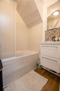a white bathroom with a shower and a tub at Appartement centre ville Calais Ines in Calais +26 photos