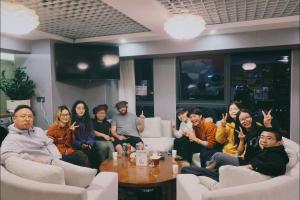 un gruppo di persone seduti in una stanza di Yunbo Youth Hostel Ürümqi a Ürümqi