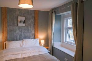 a bedroom with a bed and a window at Hycemoor Escape-Private Hot tub in Corney