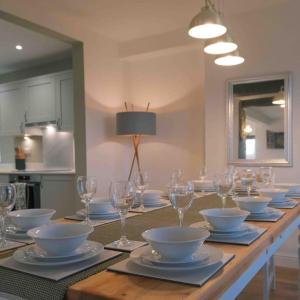 a long table with bowls and plates and wine glasses at Hycemoor Escape-Private Hot tub in Corney
