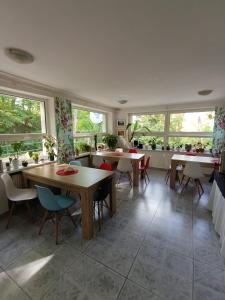a dining room with tables and chairs and windows at Pensjonat Sokolec in Sokolec