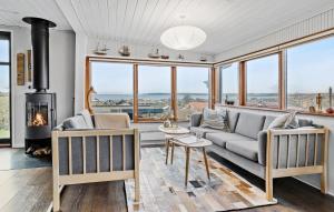 een woonkamer met een bank en een open haard bij 3 Bedroom Cozy Home In Juelsminde in Sønderby