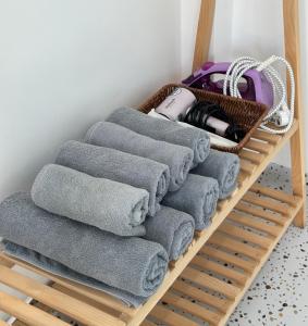 a bunch of towels on a shelf with a basket at NẮNG Homestay - Làng Chài Mũi Né - Mui Ne Fishing Village in Mui Ne +33 photos