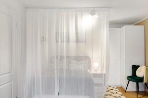 a bedroom with a bed with white curtains at Alsfelder Wein-Suite in Alsfeld