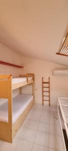 ポルト・アッズッロにあるLa casina di Adinaの二段ベッド2台とテーブルのある部屋
