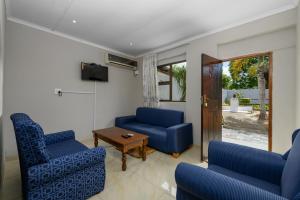 a living room with two blue chairs and a table at Resthaven in Margate