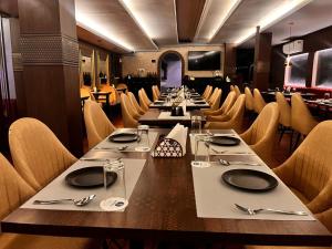 a dining room with long tables and chairs at INDUS TIARA- A Corporate Boutique Hotel in Siliguri