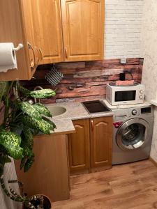 a kitchen with a washing machine and a microwave at Iidla korter in Ahtme Jaam