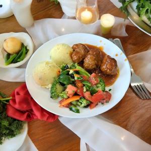 a plate of food with potatoes and vegetables on a table at Dom myśliwski in Mosty