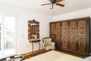 a bedroom with a large wooden cabinet and a mirror at House Villa Oaza in Rogoznica
