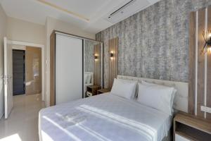 um quarto com uma cama branca e uma parede em Seasight Suites em Kusadası