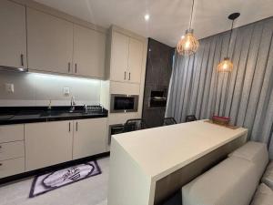 a kitchen with a white counter top in a room at Apto com piscina aquecida perto do mar in Bombinhas