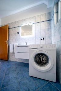 a washing machine in a bathroom with a sink at Apartments BePa in Lopar
