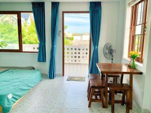 a bedroom with a desk and a bed and a table at NẮNG Homestay - Làng Chài Mũi Né - Mui Ne Fishing Village in Mui Ne