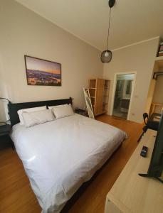 a bedroom with a large white bed and a table at Room - Garden - private bathroom in Turin