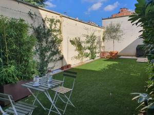 a small garden with two chairs and a table in a yard at Room - Garden - private bathroom in Turin