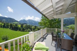 a porch with a table and chairs and mountains at Appartements Lehenhof in Sankt Johann im Pongau