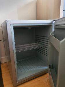 an empty refrigerator with its door open in a kitchen at Room - Garden - private bathroom in Turin