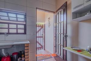 a kitchen with an open door to a room at Casa em São Sebastião a 5 min da Praia in São Sebastião