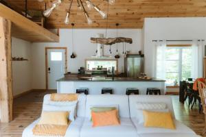 a living room with a couch and a kitchen at L'Echappee Belle - lake and SPA in Saint Come